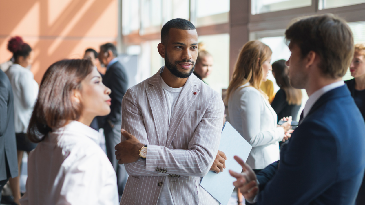 Business professionals engaged in conversation at a networking event, exchanging ideas and building connections.